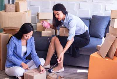 Young woman sitting on sofa in box