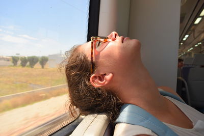 Close-up of woman relaxing on a train window