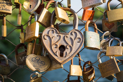 Close-up of padlocks hanging on chainlink fence