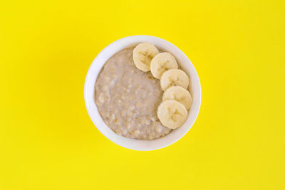 Directly above shot of breakfast in bowl against yellow background