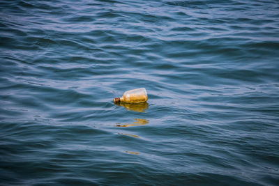 High angle view of bottle floating on sea