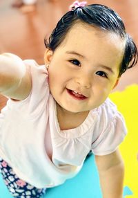 Close-up portrait of smiling baby girl playing at home