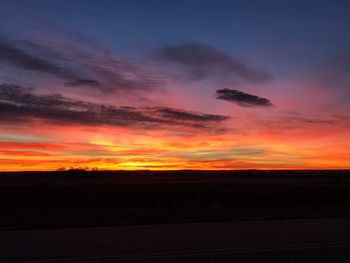 Scenic view of silhouette landscape against orange sky