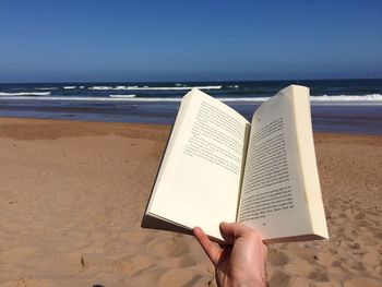 Close-up of reading book on beach