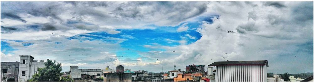 View of residential buildings against cloudy sky