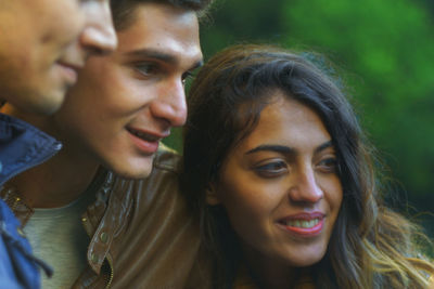 Close-up of smiling young friends looking away