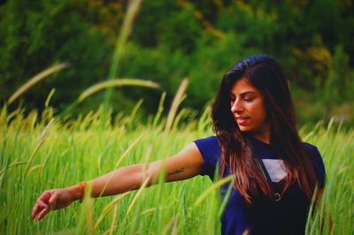 Portrait of woman standing on grassy field