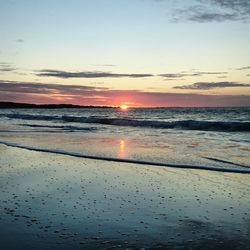 Scenic view of beach against sky at sunset