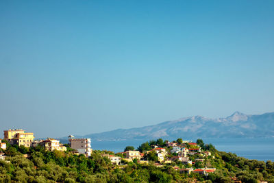 Buildings and trees against blue sky