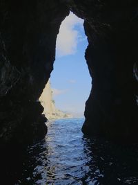 Scenic view of sea seen through cave