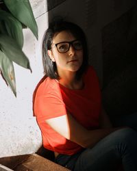 Young woman looking away while sitting at home