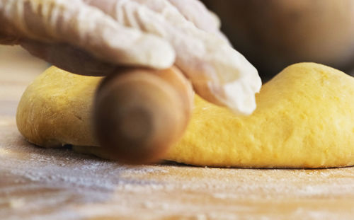 Close-up of wooden rolling pin and dough