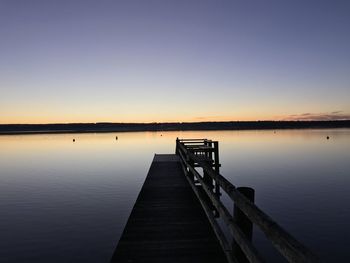 Pier over lake against sky during sunset