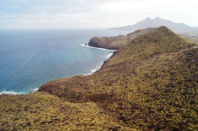 Scenic view of sea and mountains against sky