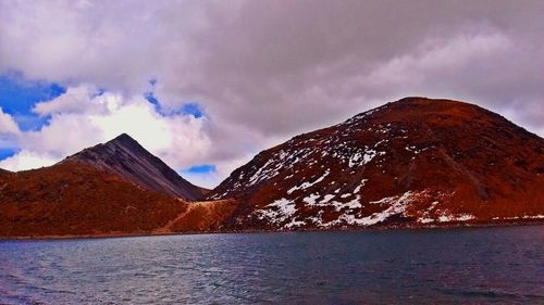 Scenic view of mountains against cloudy sky