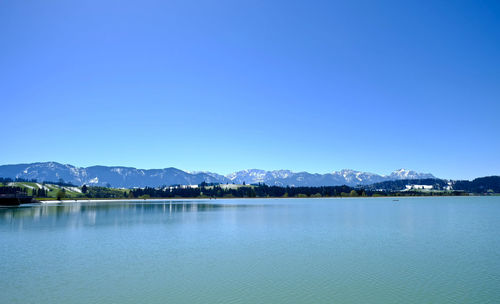 Scenic view of lake against clear blue sky