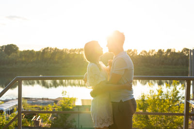 Couple standing on bridge against sky