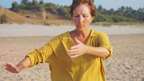 Midsection of woman standing on beach