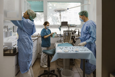 Veterinarians and female nurse preparing for surgery in operating room at hospital