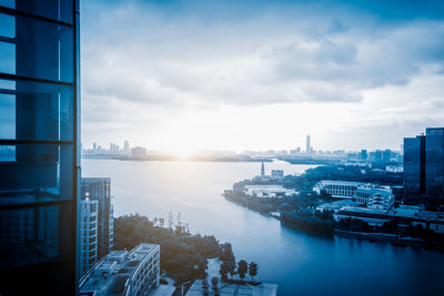 High angle view of city buildings against cloudy sky