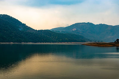 Lake calm water with mountain background at day from flat angle