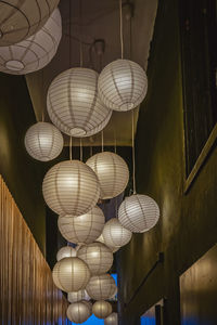 Low angle view of illuminated pendant lights hanging from ceiling