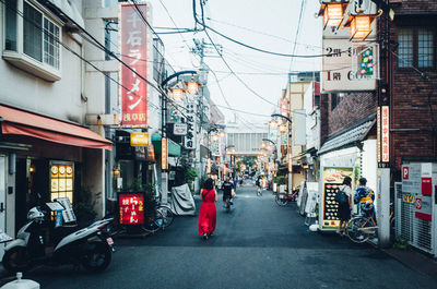 People on street amidst buildings in city