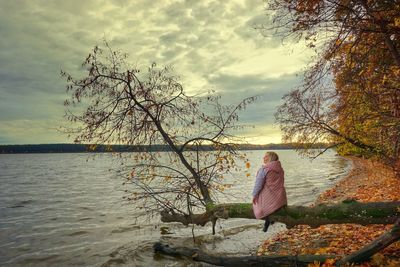 Rear view of woman looking at sea against sky