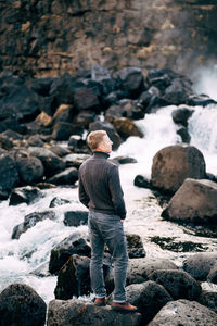 Rear view of man standing on rock