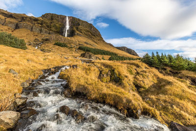 Scenic view of waterfall against sky