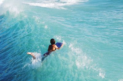 Rear view of shirtless man in sea