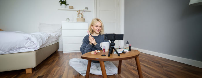 Woman sitting on table at home
