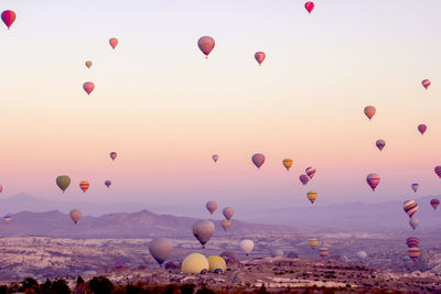 Hot air balloons flying over landscape against sky