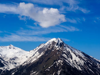 Scenic view of snowcapped mountains against blue sky