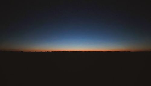 Silhouette landscape against clear sky during sunset