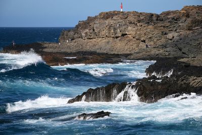 Scenic view of rocks in sea against sky