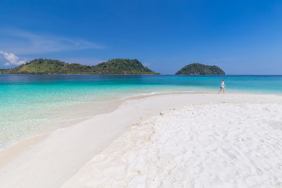 Scenic view of beach against blue sky