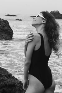 Portrait of young woman standing at beach