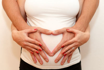 Midsection of woman touching heart