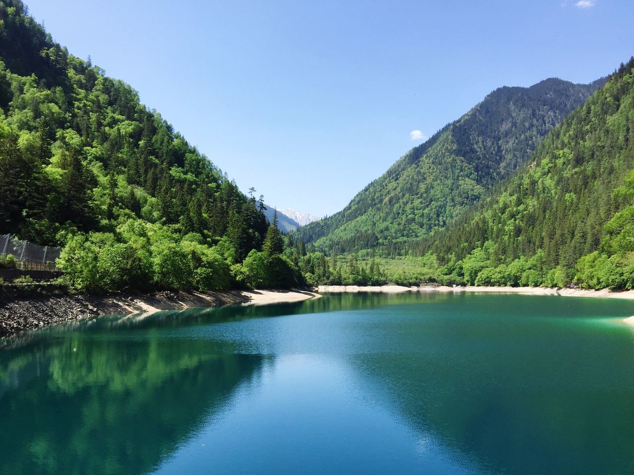 water, beauty in nature, tranquil scene, nature, tranquility, scenics, mountain, lake, waterfront, tree, outdoors, idyllic, no people, day, clear sky, reflection, blue, green color, sky