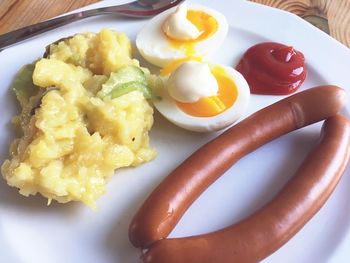 High angle view of wiener sausages, eggs and potato salad served in plate