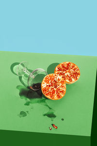 Studio shot of halved pomegranate and knocked down glass of pomegranate juice
