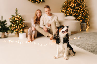 A couple in love hugging and relaxing on a christmas holiday in the decorated interior of the house