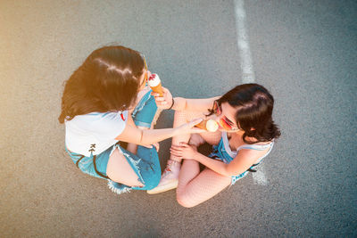 High angle view of mother and daughter holding umbrella