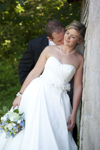 Happy couple kissing against plants