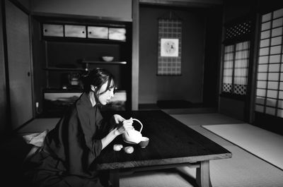 Woman sitting on table at home