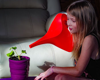 Side view of young woman sitting on sofa at home