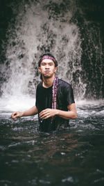 Full length of young man splashing water