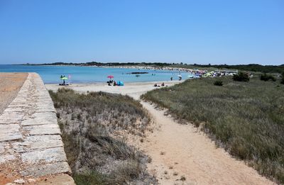 Scenic view of beach against clear blue sky