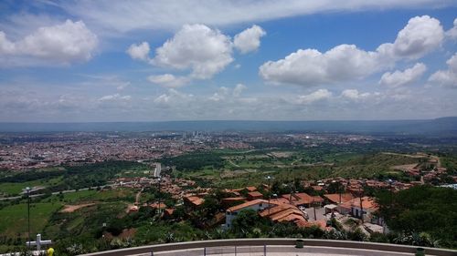 Aerial view of city against cloudy sky